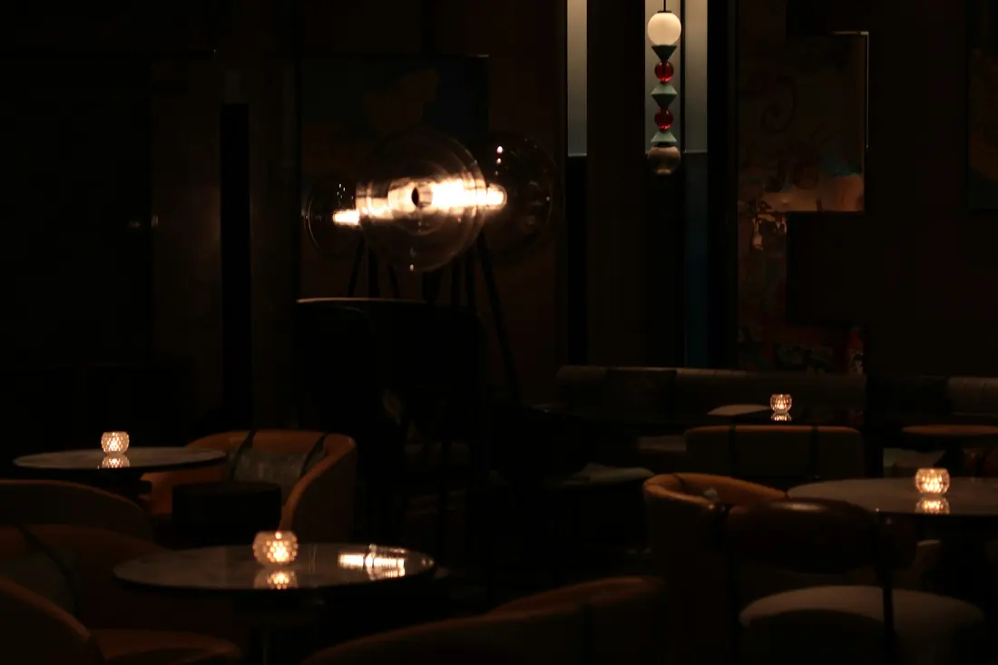 A dimly lit lounge with tables and candles