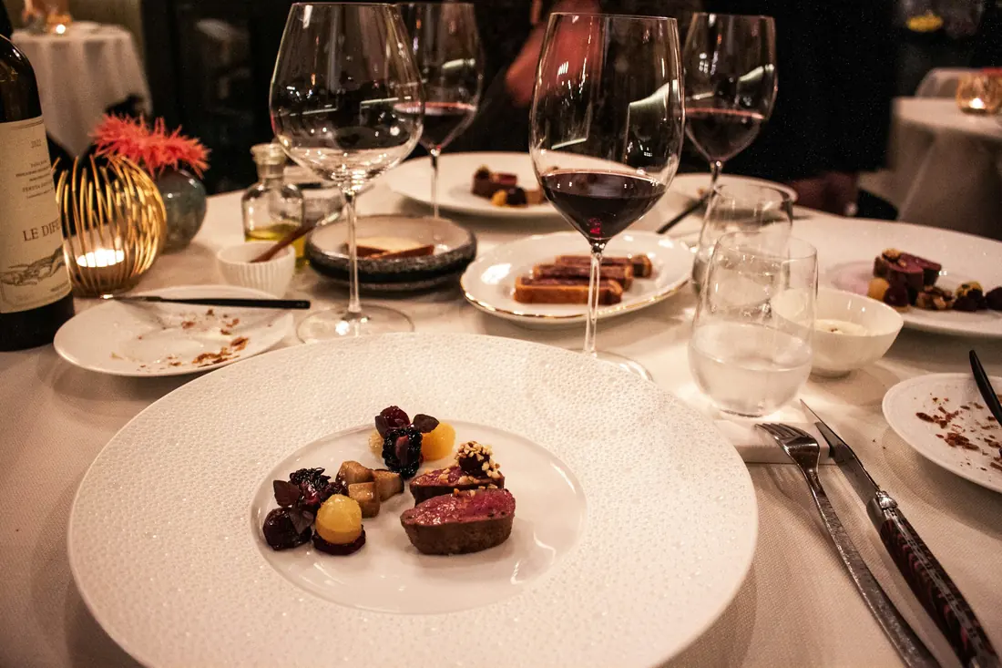 A set restaurant table with wine glasses and plated dishes